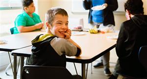 student at table smiles